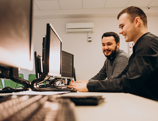 dos hombres frente a varios pc